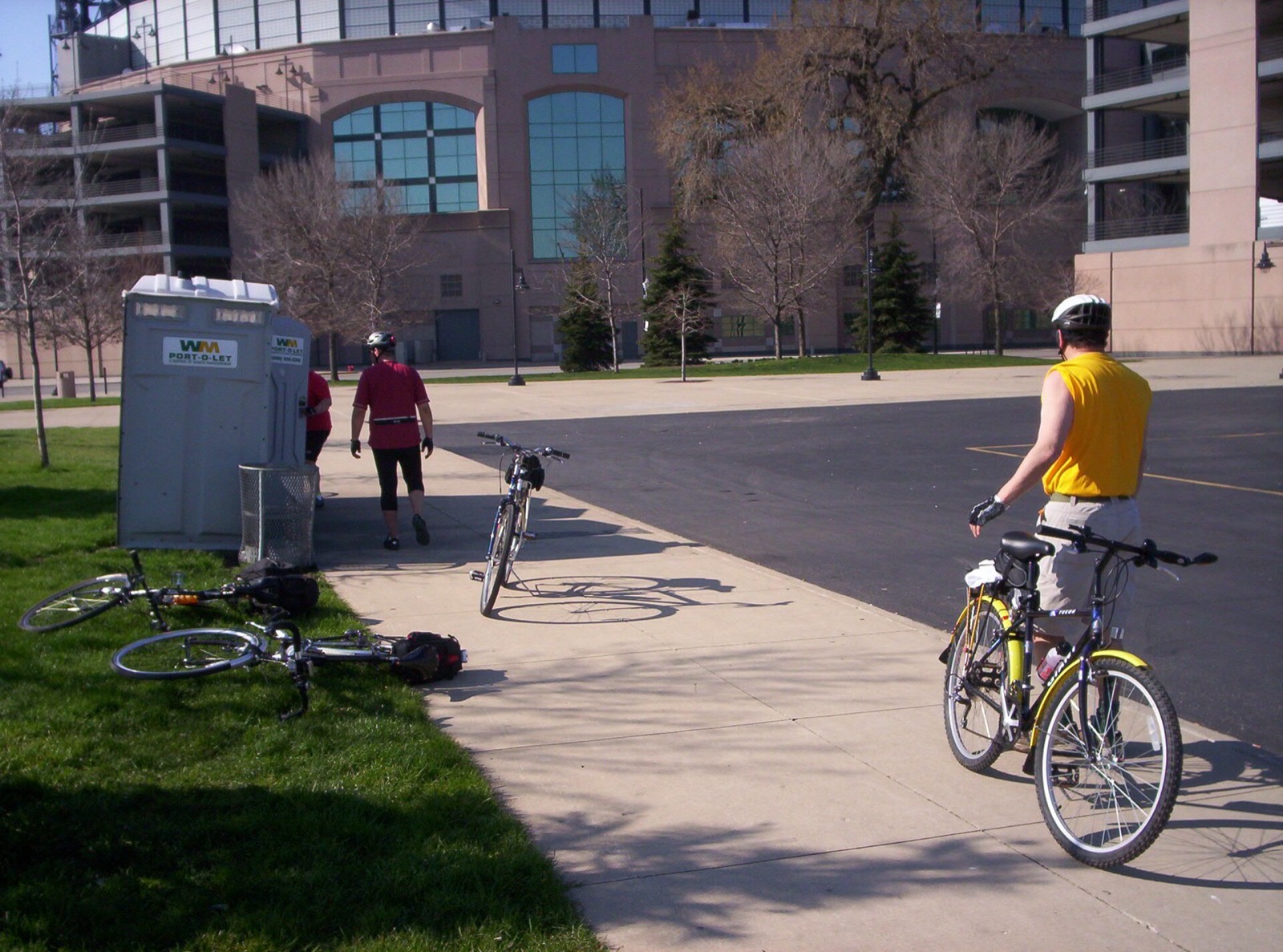 Cyclists stopped beside a paved path on a spring club ride