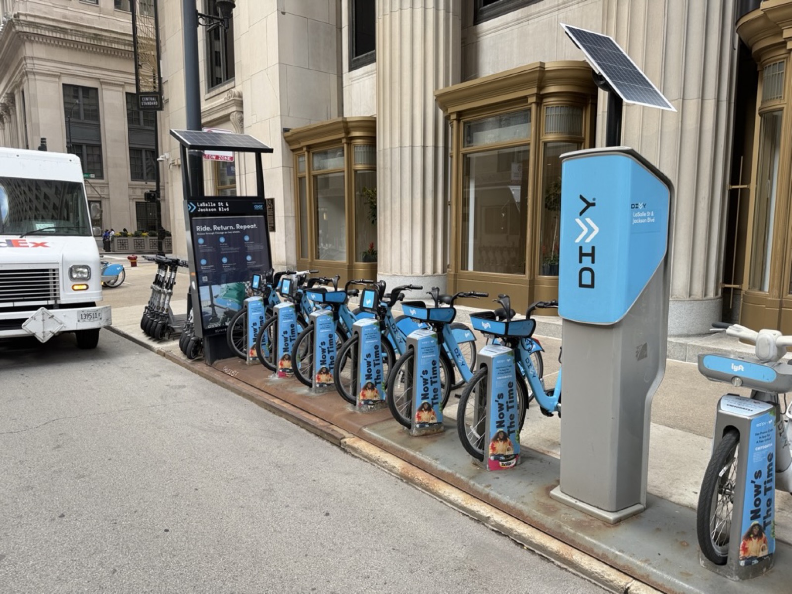 A row of blue Divvy bikes locked at a downtown Chicago docking station