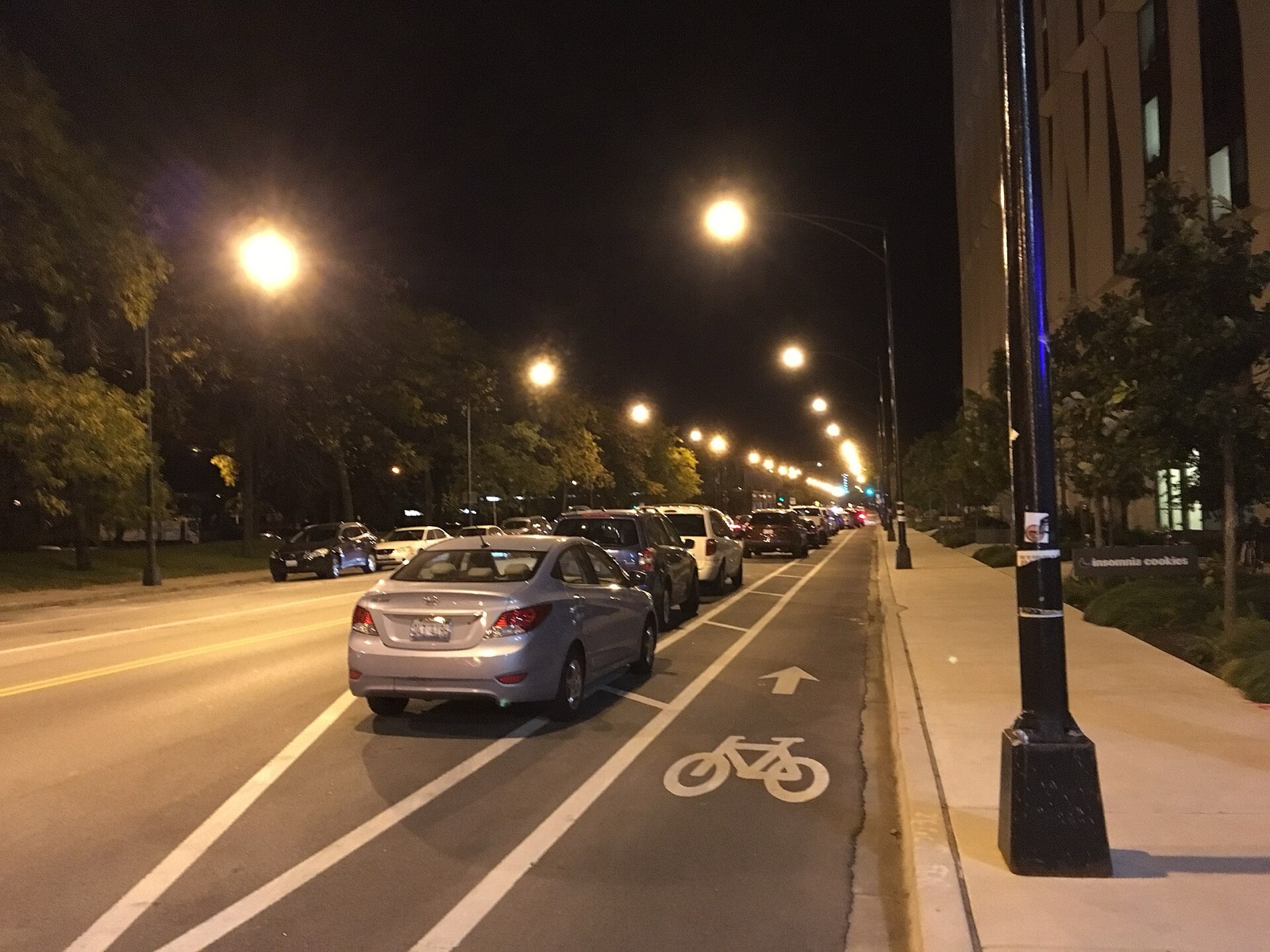 A parking-protected bike lane on 55th Street at night