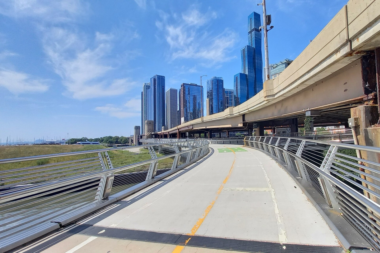 The curving paved bike path of the Navy Pier Flyover with lakefront towers ahead