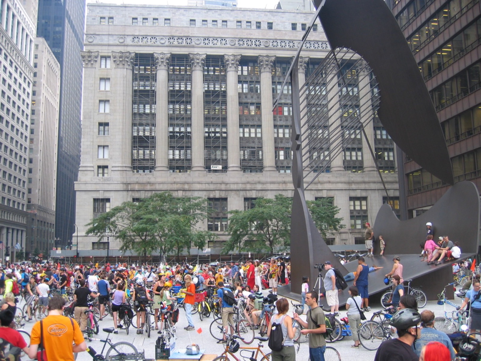 Critical Mass riders gathered with bicycles around the Picasso sculpture in Daley Plaza