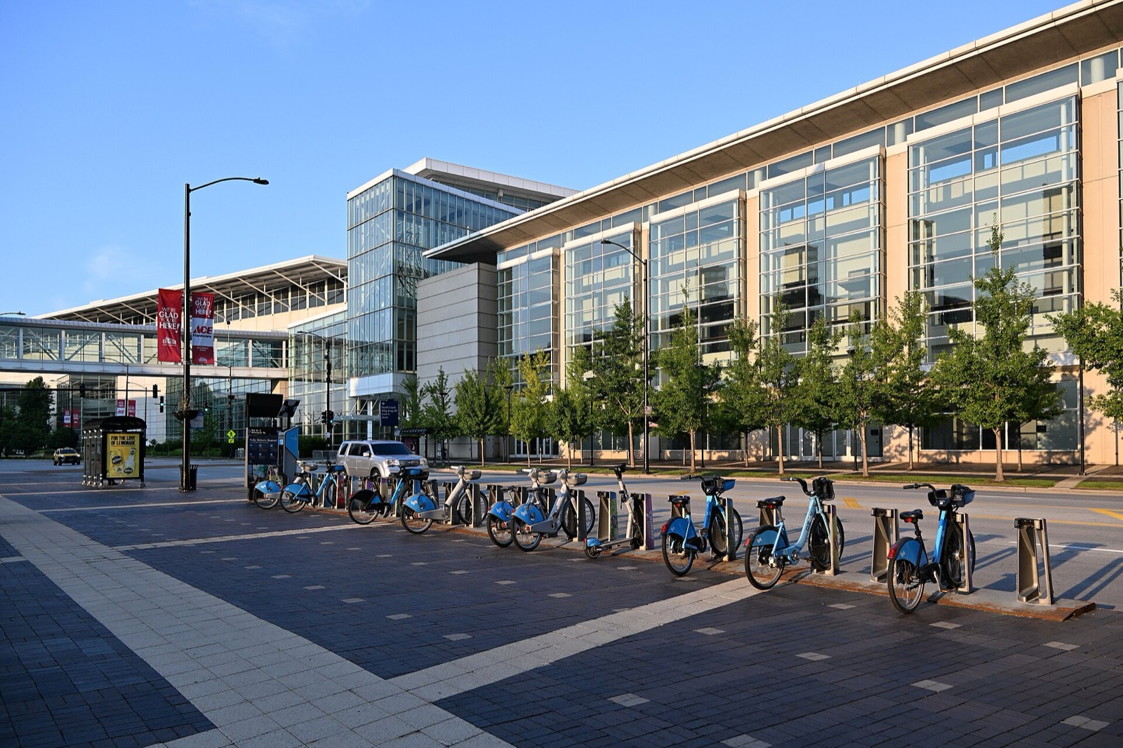 Blue Divvy bikes docked in a row on a plaza beside a convention center