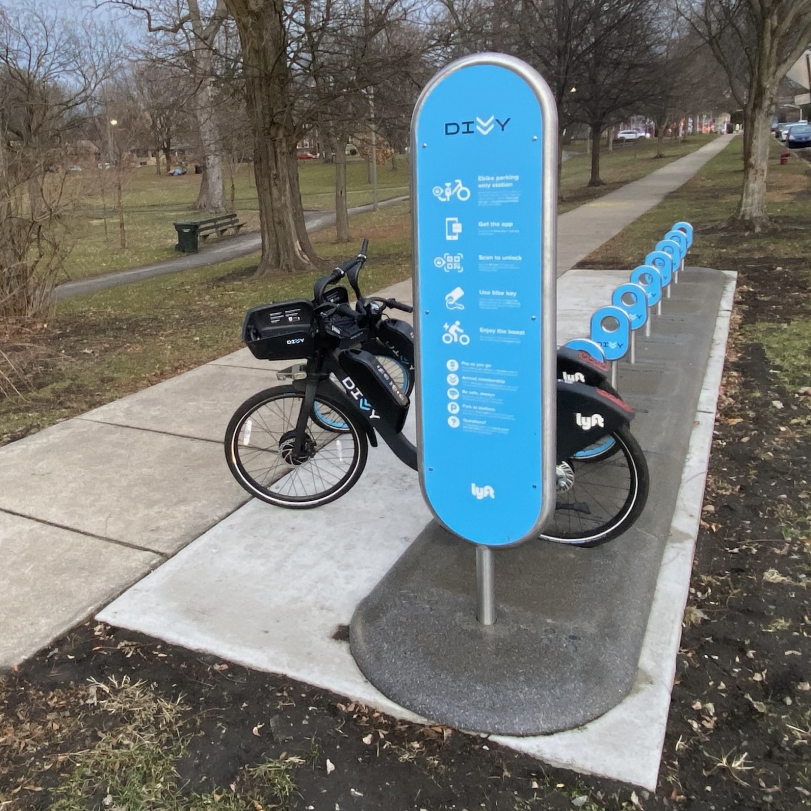 A Divvy e-bike parking station beside a park path in Chicago