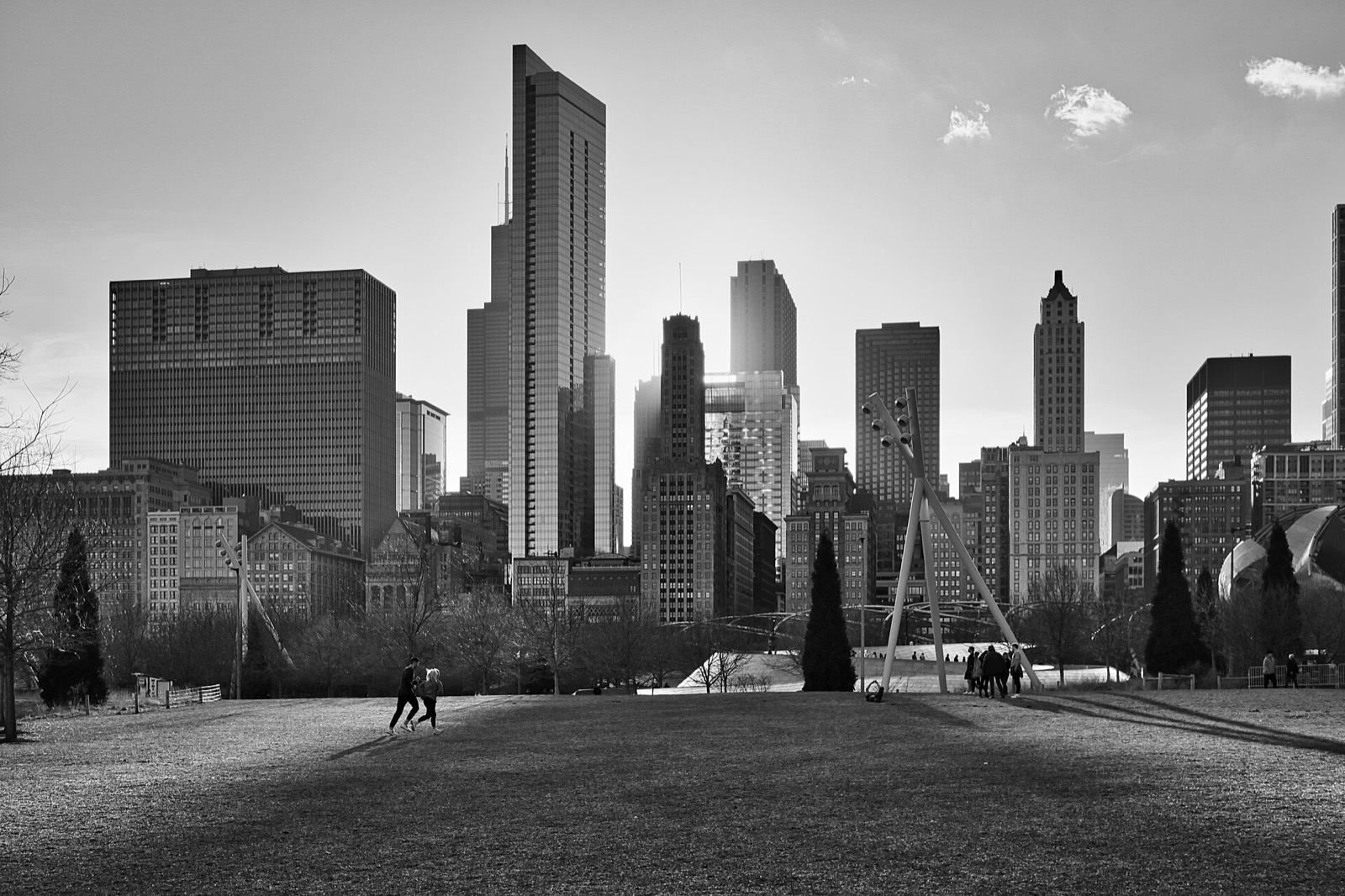 Downtown Chicago skyscrapers above the open lawn of Maggie Daley Park, in black and white