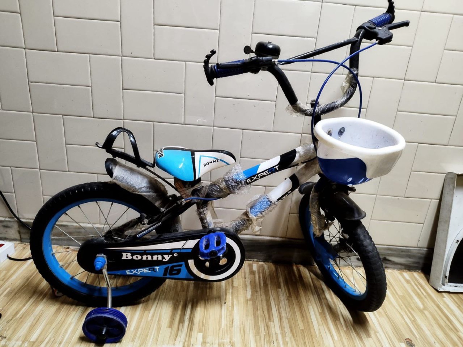 A child's bicycle with training wheels and a front basket