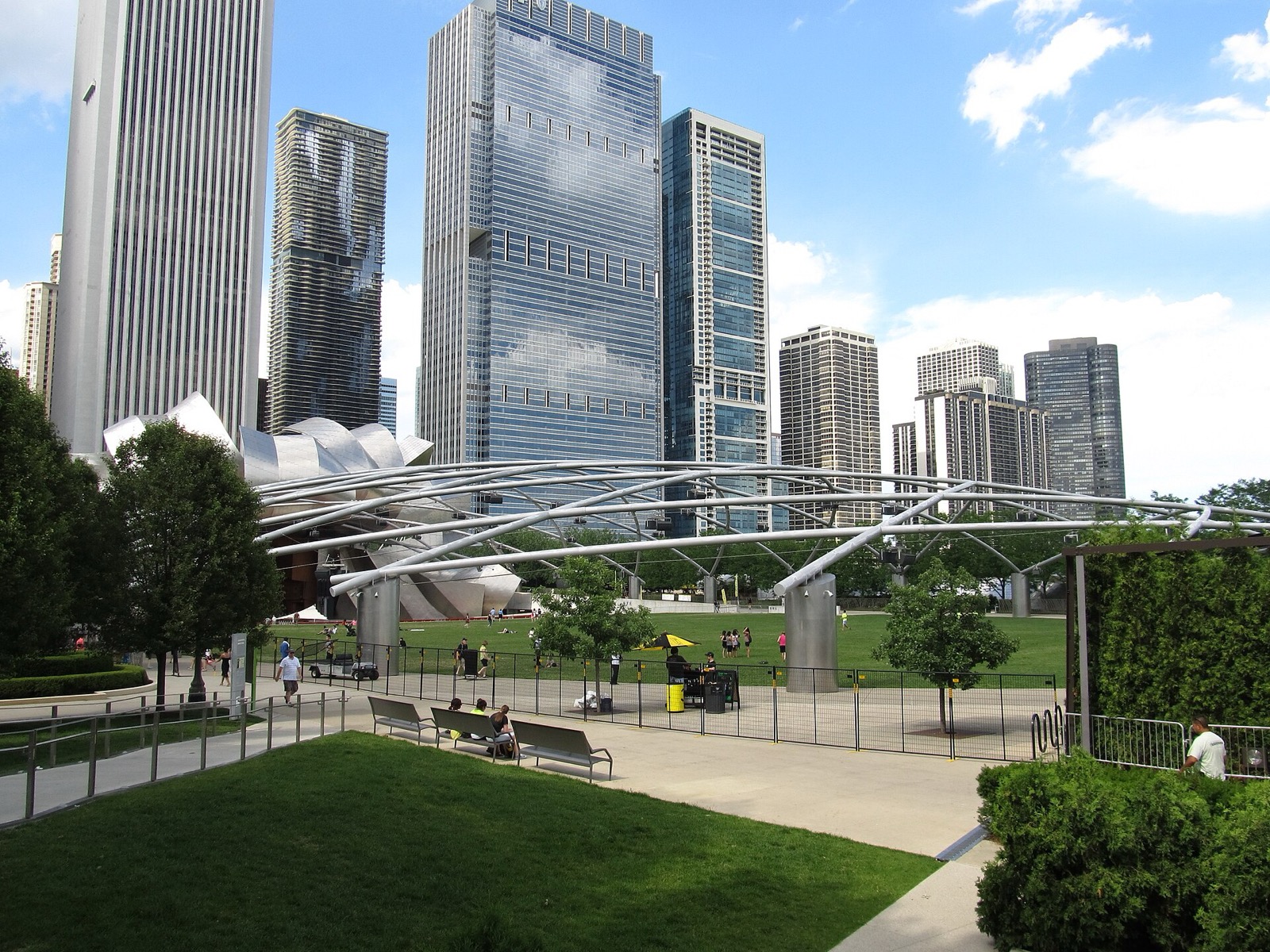 Millennium Park lawn and Jay Pritzker Pavilion trellis beneath Michigan Avenue towers